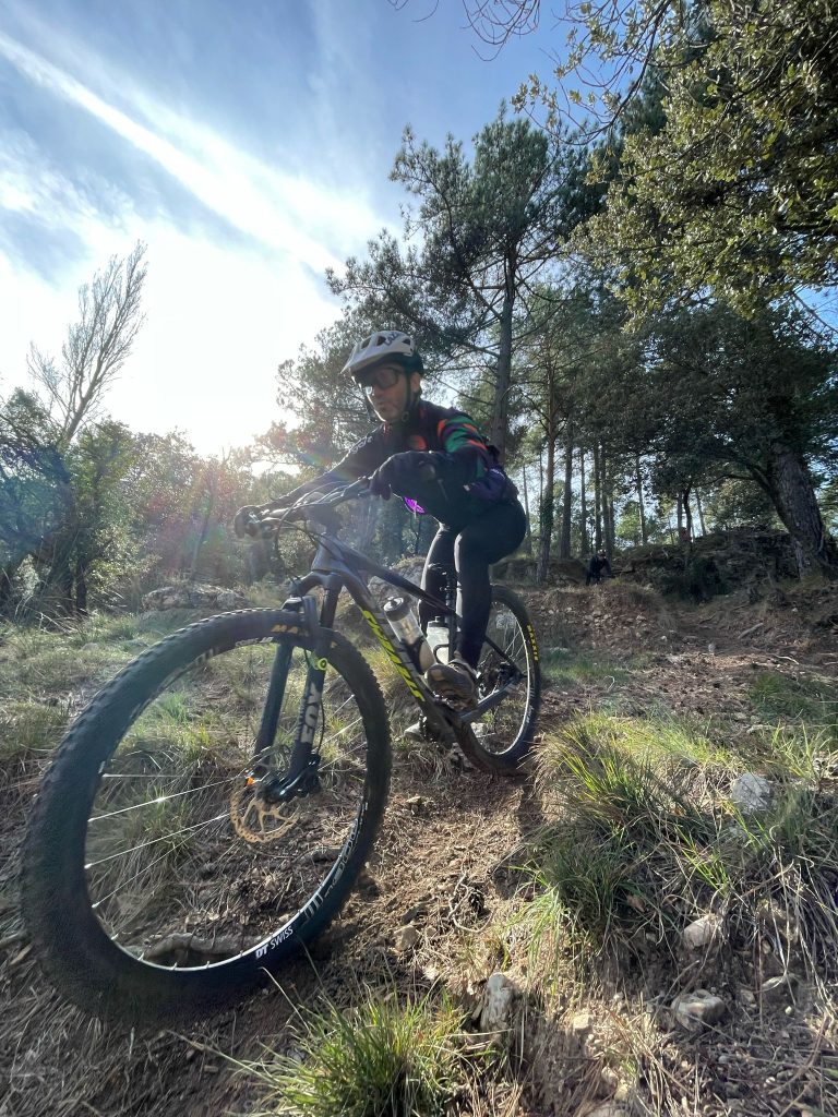 Jordi montando en MTB en un sendero entre pinos