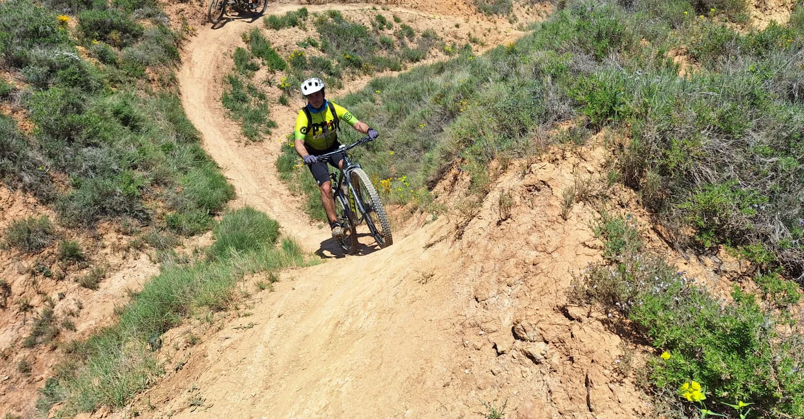 Jordi bajando en MTB por el Afganistrail, un sendero de tierra con curvas, en Tremp