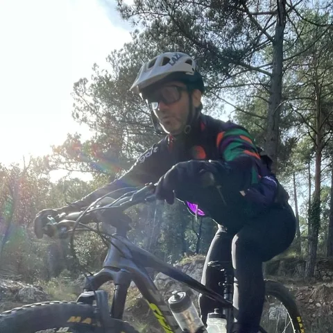 Jordi, autor de ZonaMTB, bajando en MTB por un sendero entre pinos